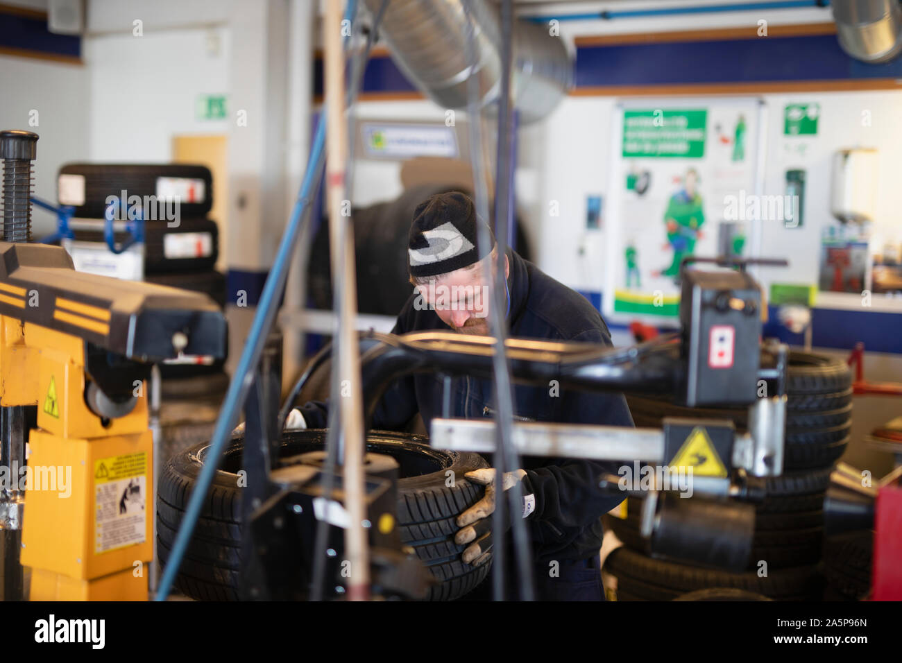 Man changing tire in garage Stock Photo Alamy