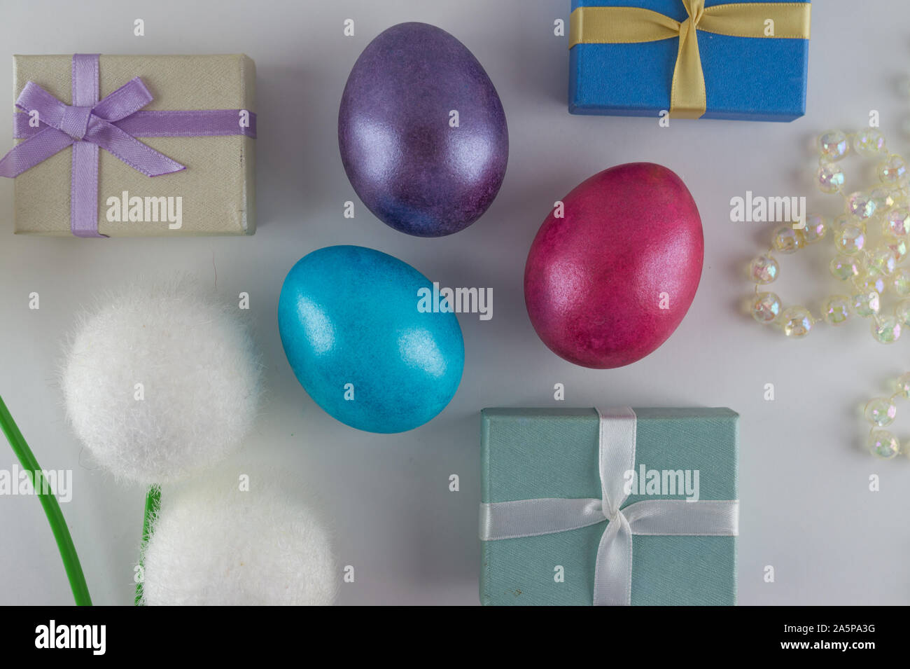 White Easter flat lay background with painted Easter eggs and gift boxes. Stock Photo