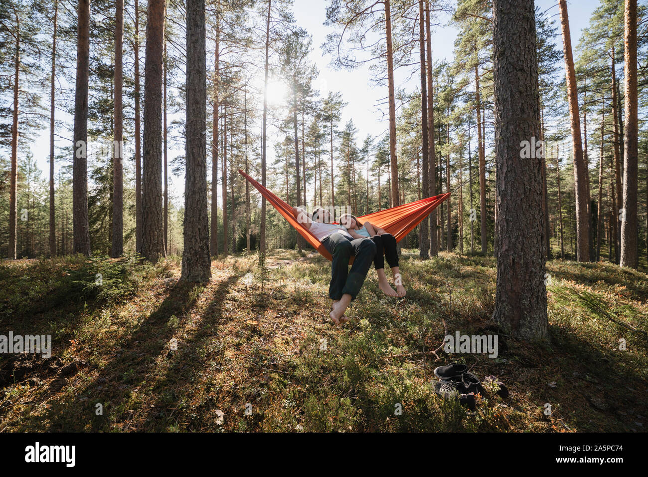 Young couple lying in hammock in forest Stock Photo