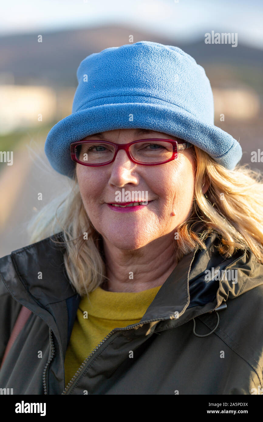 Older woman with glasses wearing a blue wool hat, Waterville, County Kerry, Ireland Stock Photo
