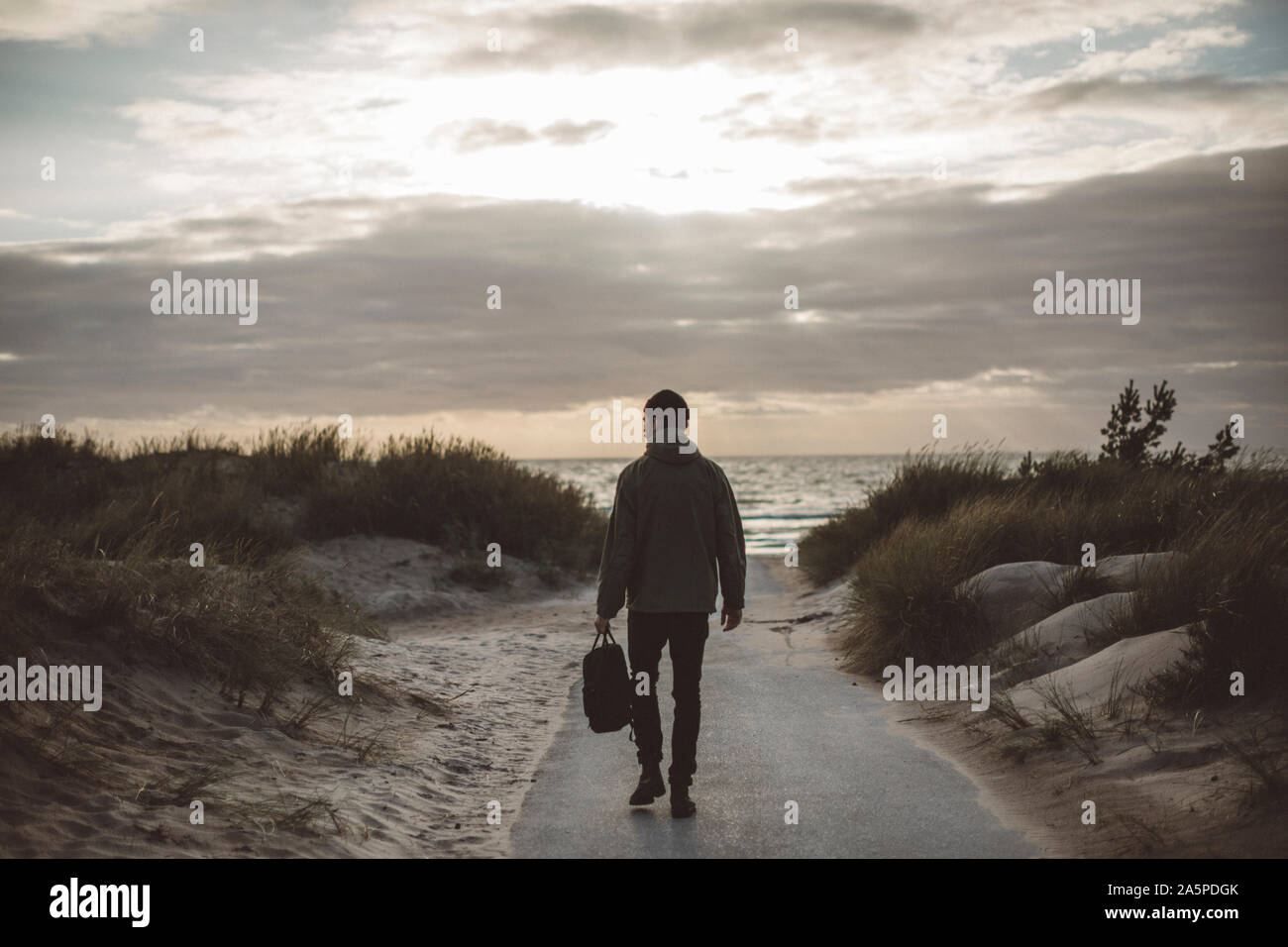Man walking on beach Stock Photo - Alamy