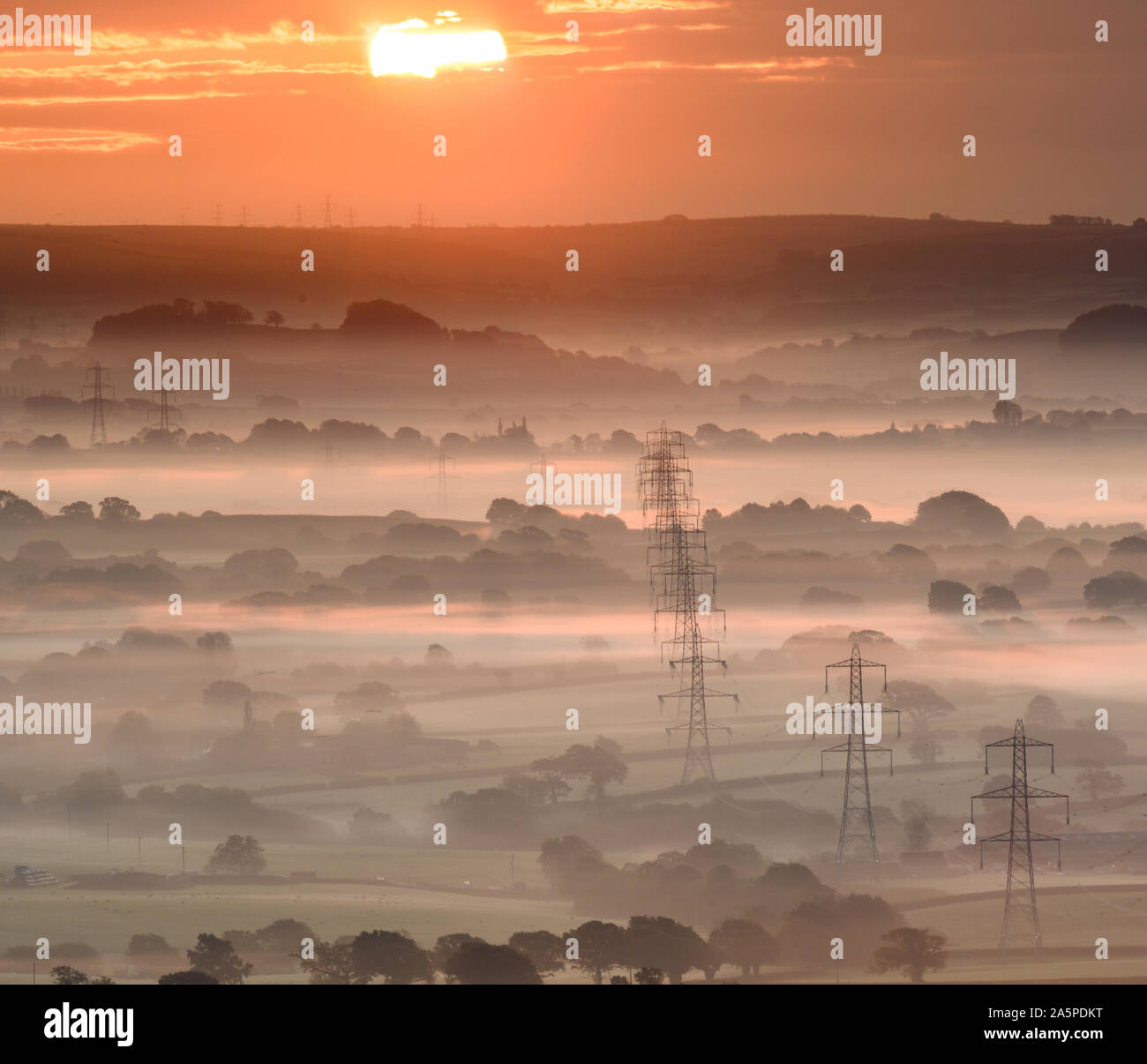 Marshwood Vale, Bridport, Dorset, UK. 22nd October 2019. UK Weather: Trees and electricity pylons emerge from the layers of early morning mist at Marshwood Vale on a chilly autumnal morning. Credit: Celia McMahon/Alamy Live News. Stock Photo