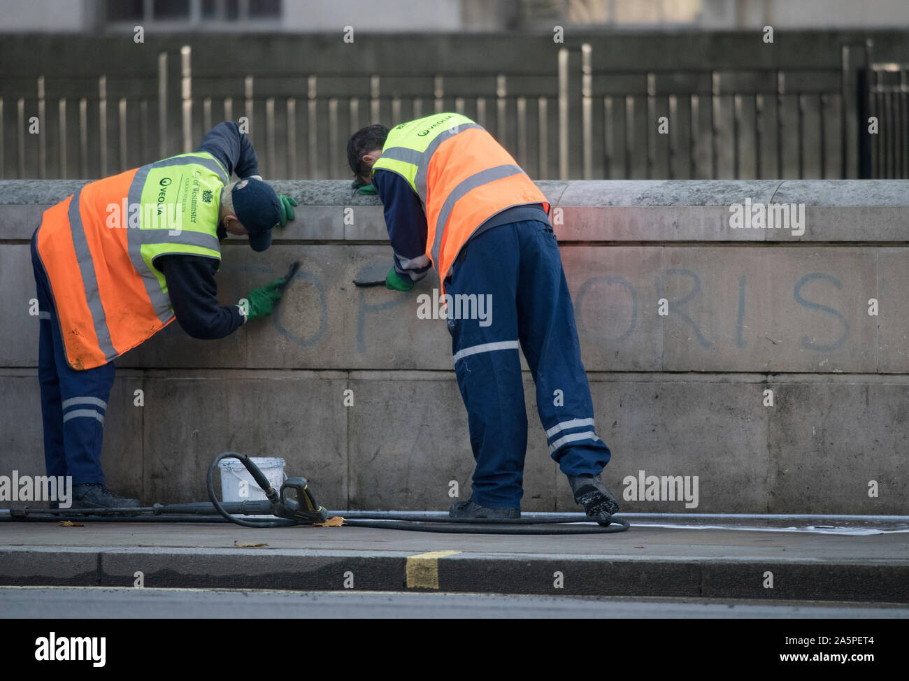 Downing Street, London, UK. 22nd October 2019. As Ministers arrive in Downing Street for weekly Cabinet, cleaners in Whitehall directly across from Downing Street entrance attempt to clean ‘Stop Boris’ graffiti from a wall. Credit: Malcolm Park/Alamy Live News. Stock Photo