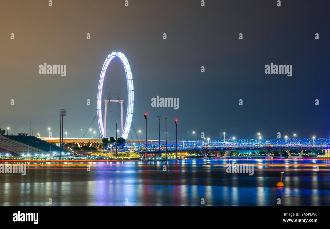 The Singapore Flyer and Helix Bridge at night Stock Photo