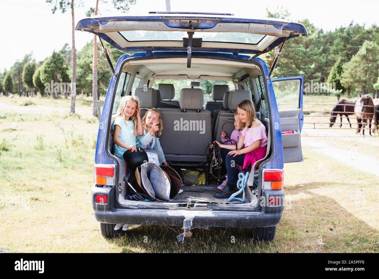 Children sitting in car trunk Stock Photo