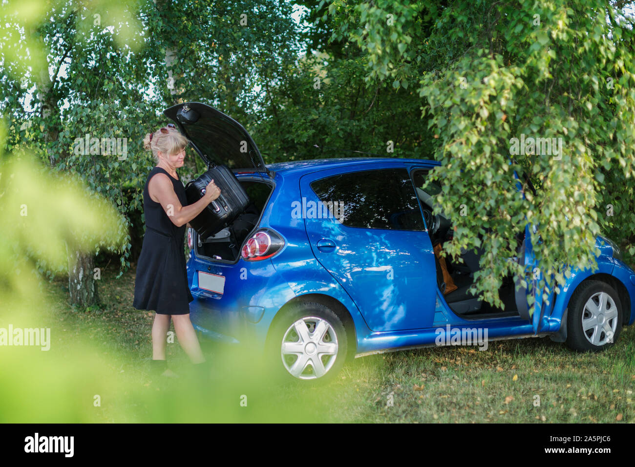 Putting luggage in car hi-res stock photography and images - Alamy