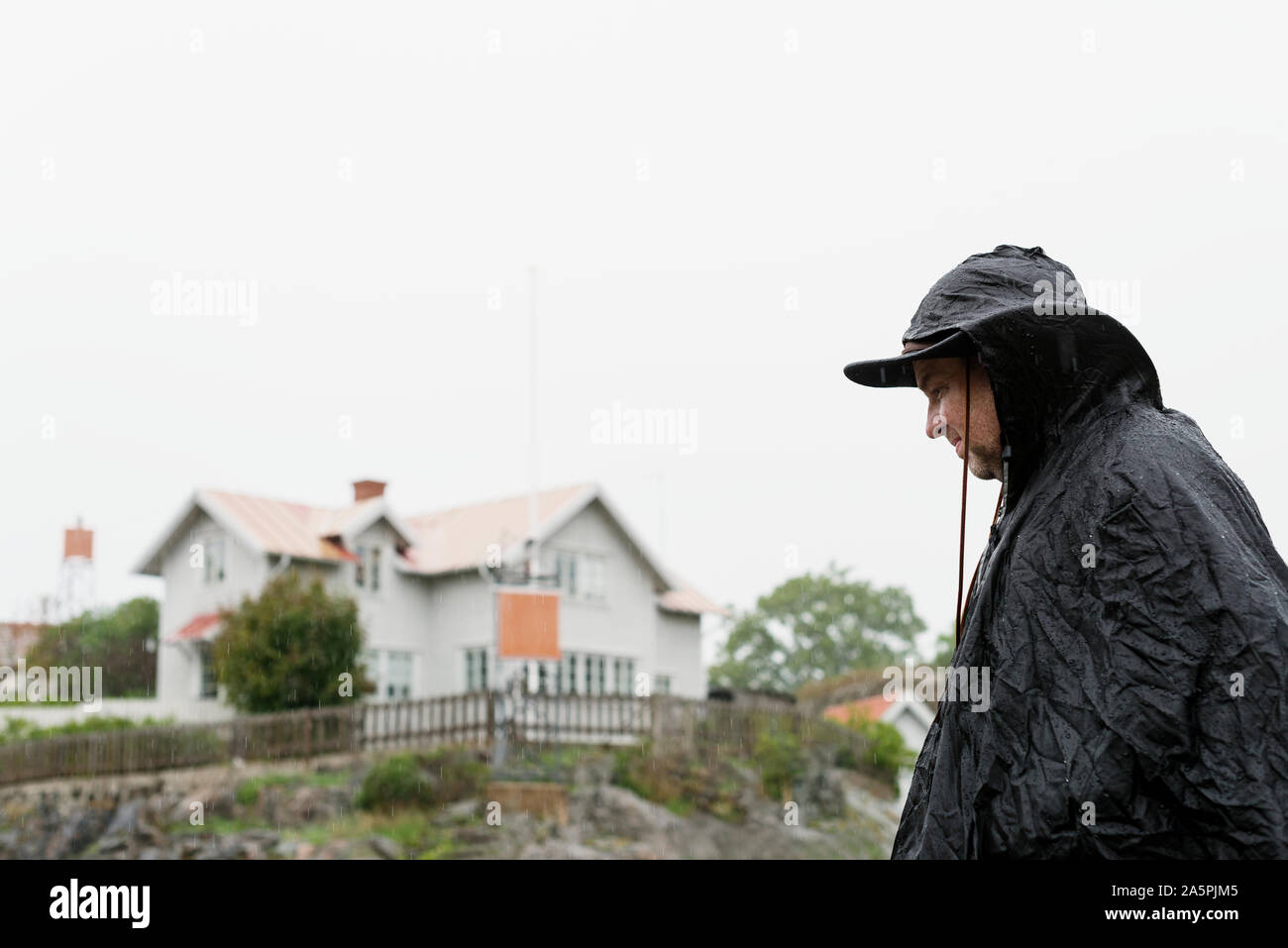Man wearing rain coat Stock Photo Alamy