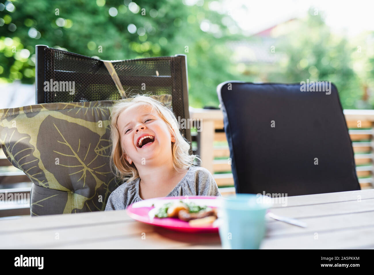 Laughing girl at table Stock Photo