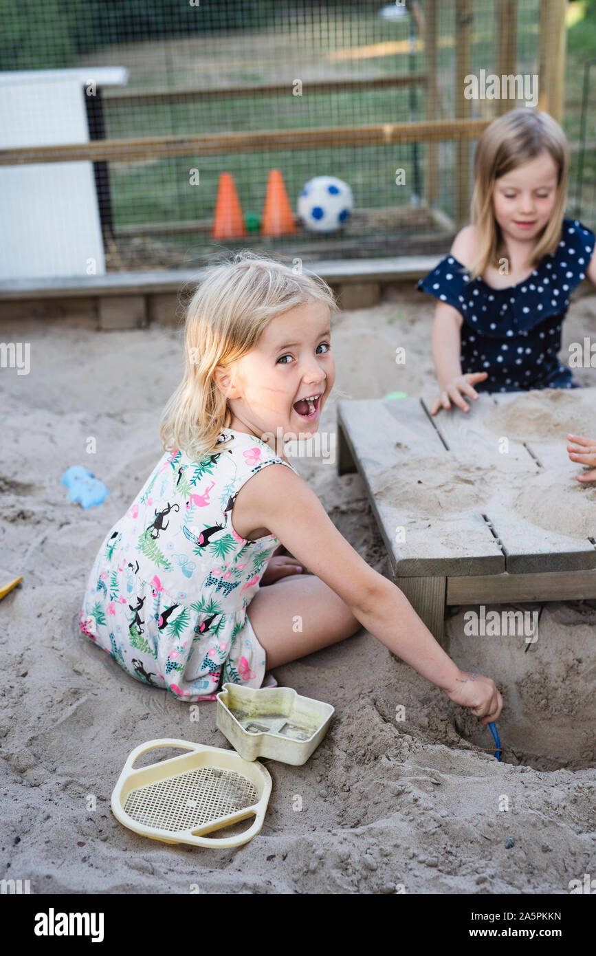 Girls playing in sandpit Stock Photo