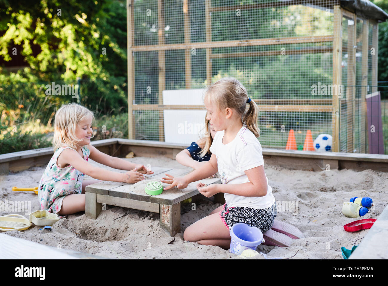 Girls playing in sandpit Stock Photo