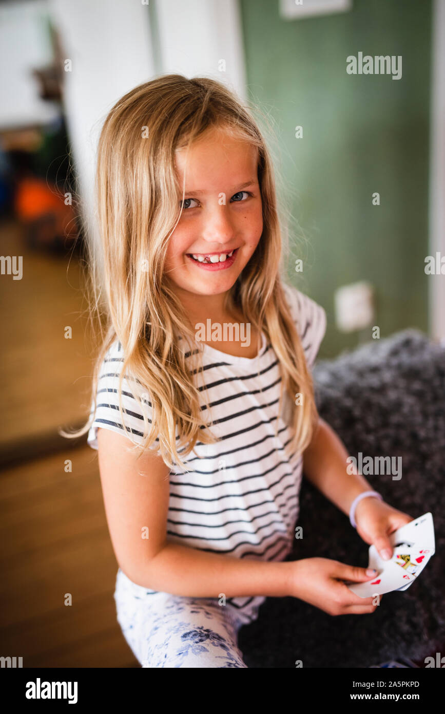Girl with playing cards looking at camera Stock Photo