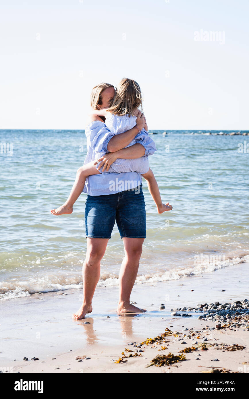 Mother with daughter on beach Stock Photo