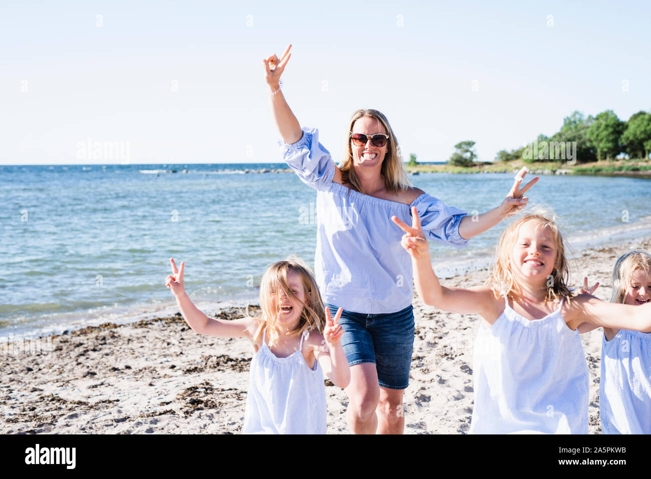 Mother with daughters on beach Stock Photo