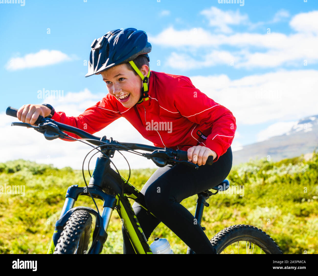 Boy riding bike in mountains Stock Photo