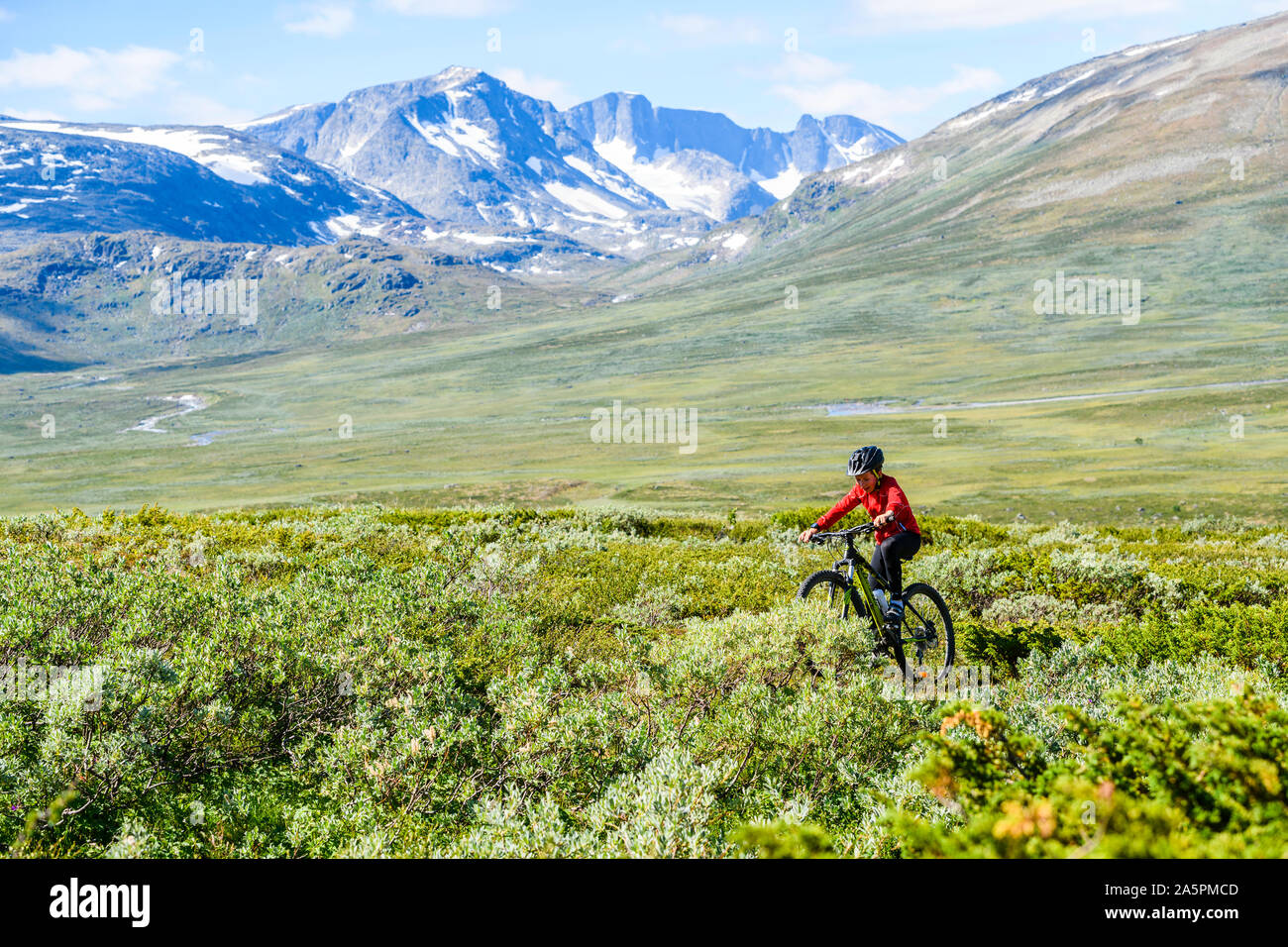 Boy riding bike in mountains Stock Photo