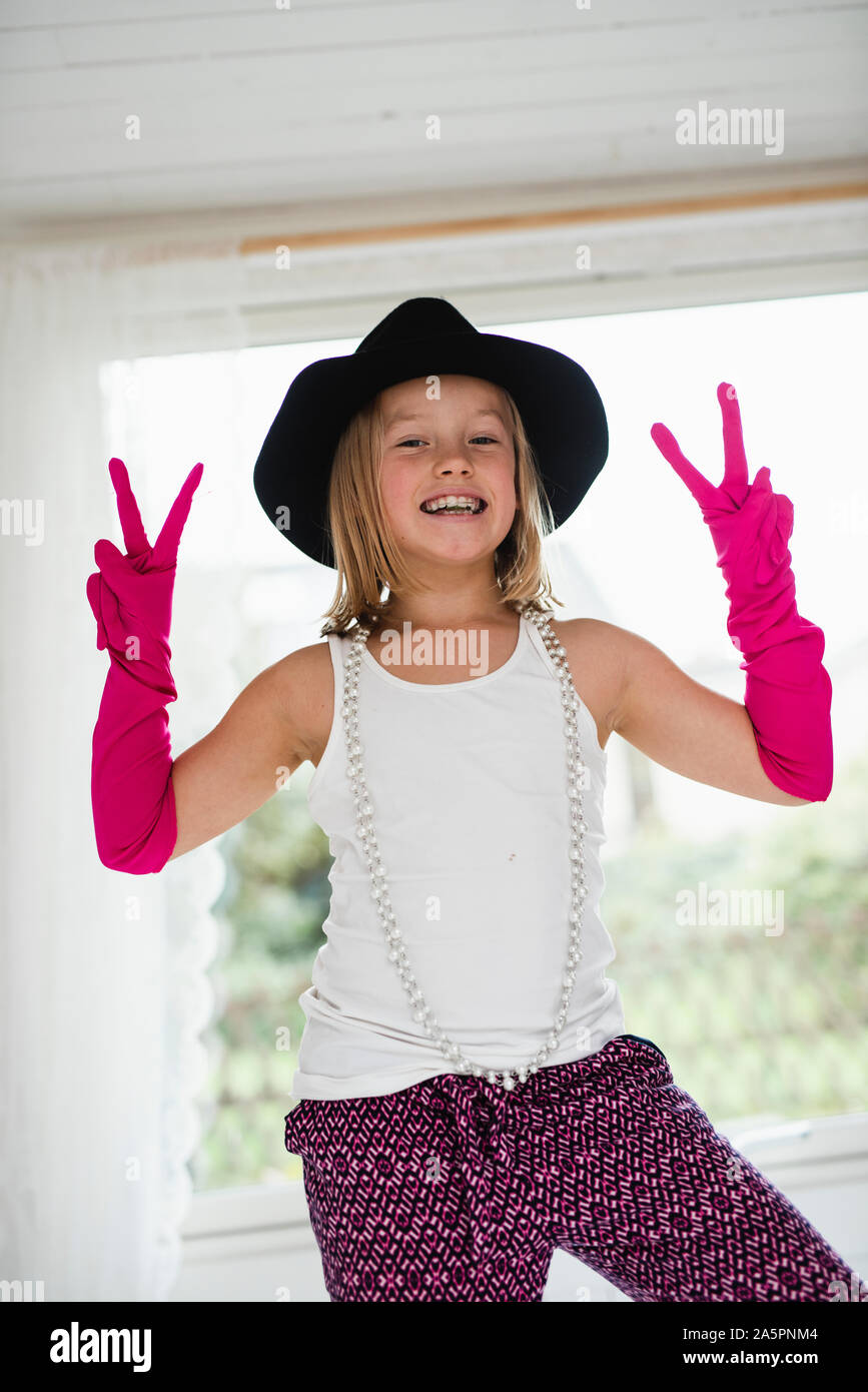 Smiling blonde girl making peace gesture Stock Photo