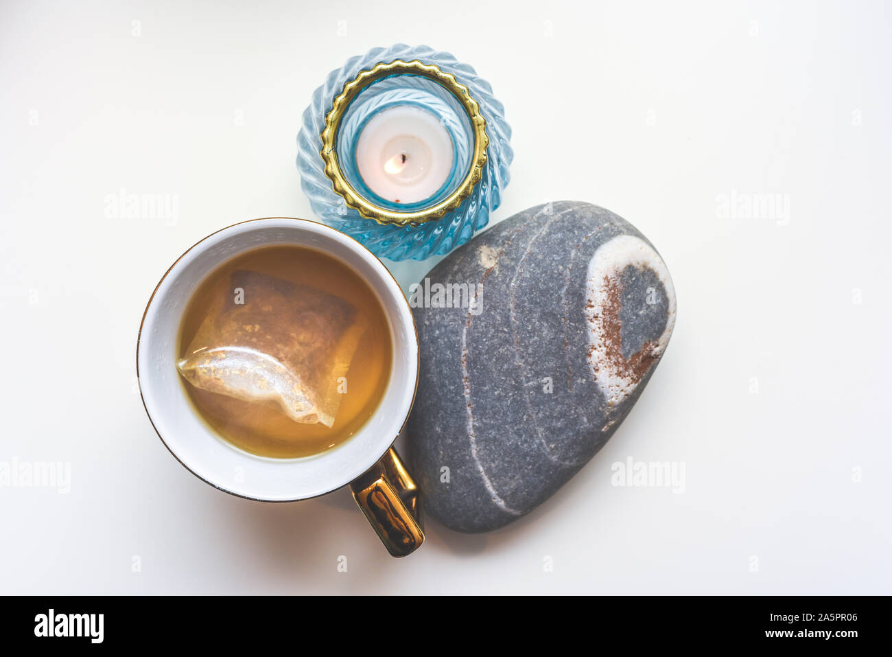 Calming camomile tea in a mug with arrangement of modern objects view from above Stock Photo