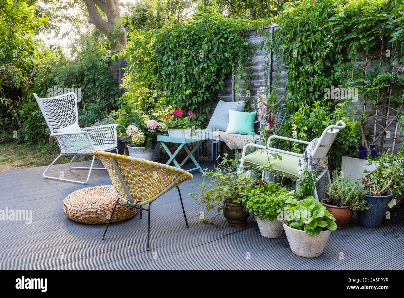 Garden furniture on decking with pot plants Stock Photo
