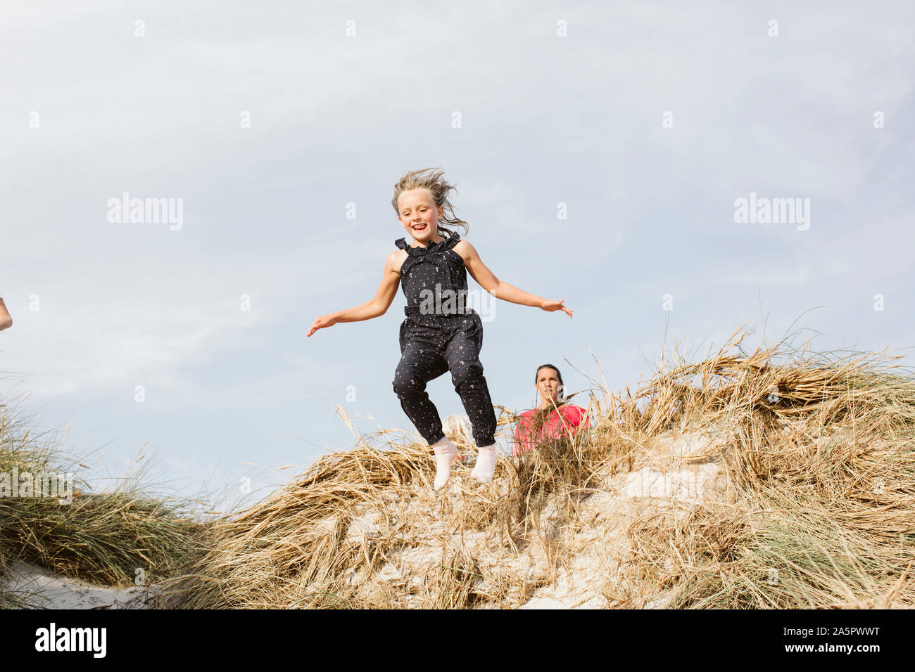 Girl jumping on sand dune Stock Photo Alamy