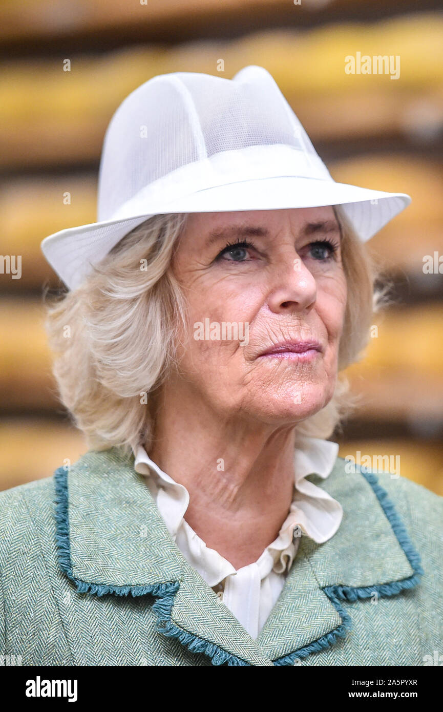 The Duchess of Cornwall wears a white food production hat during a