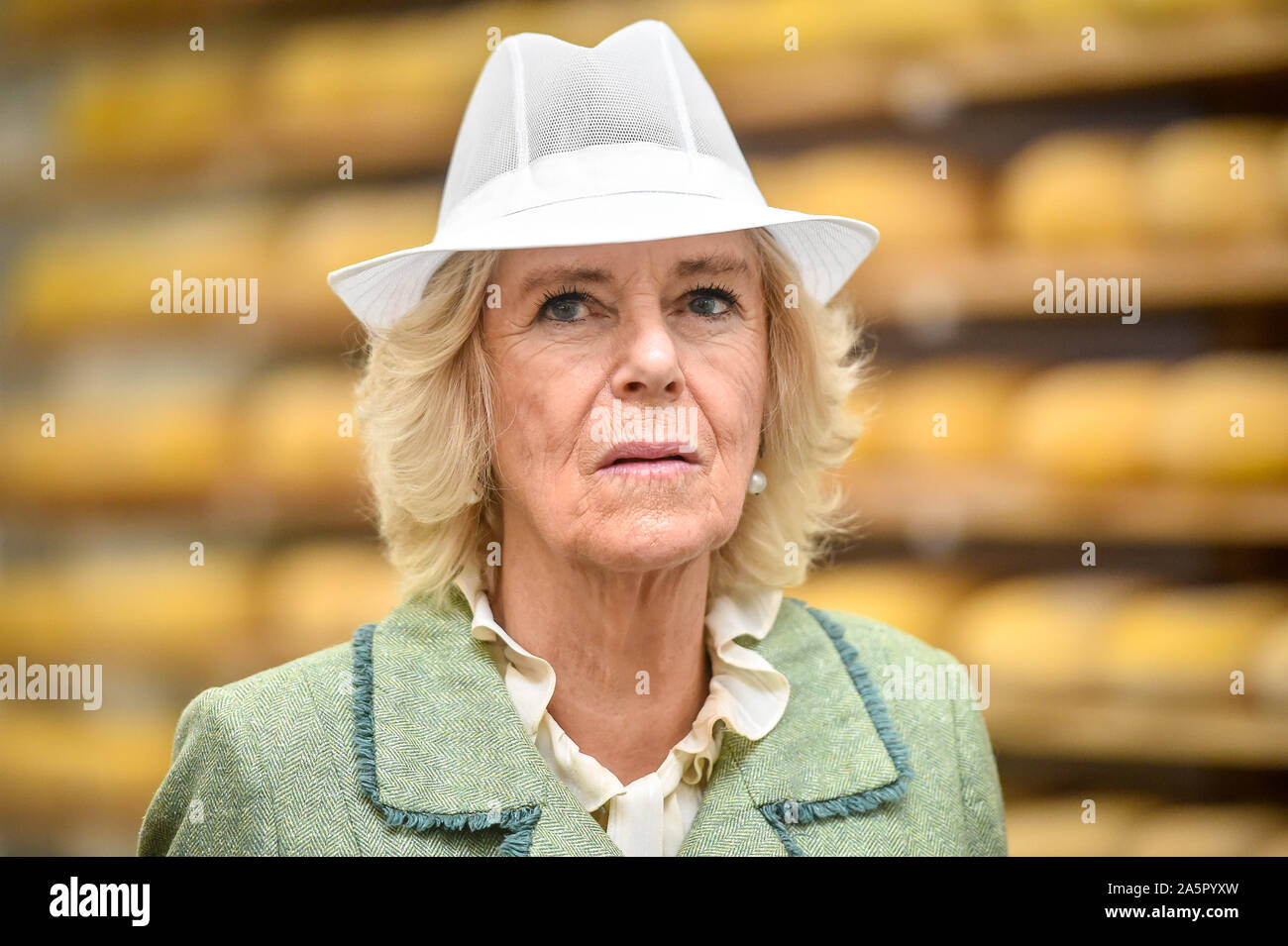 The Duchess of Cornwall wears a white food production hat during a
