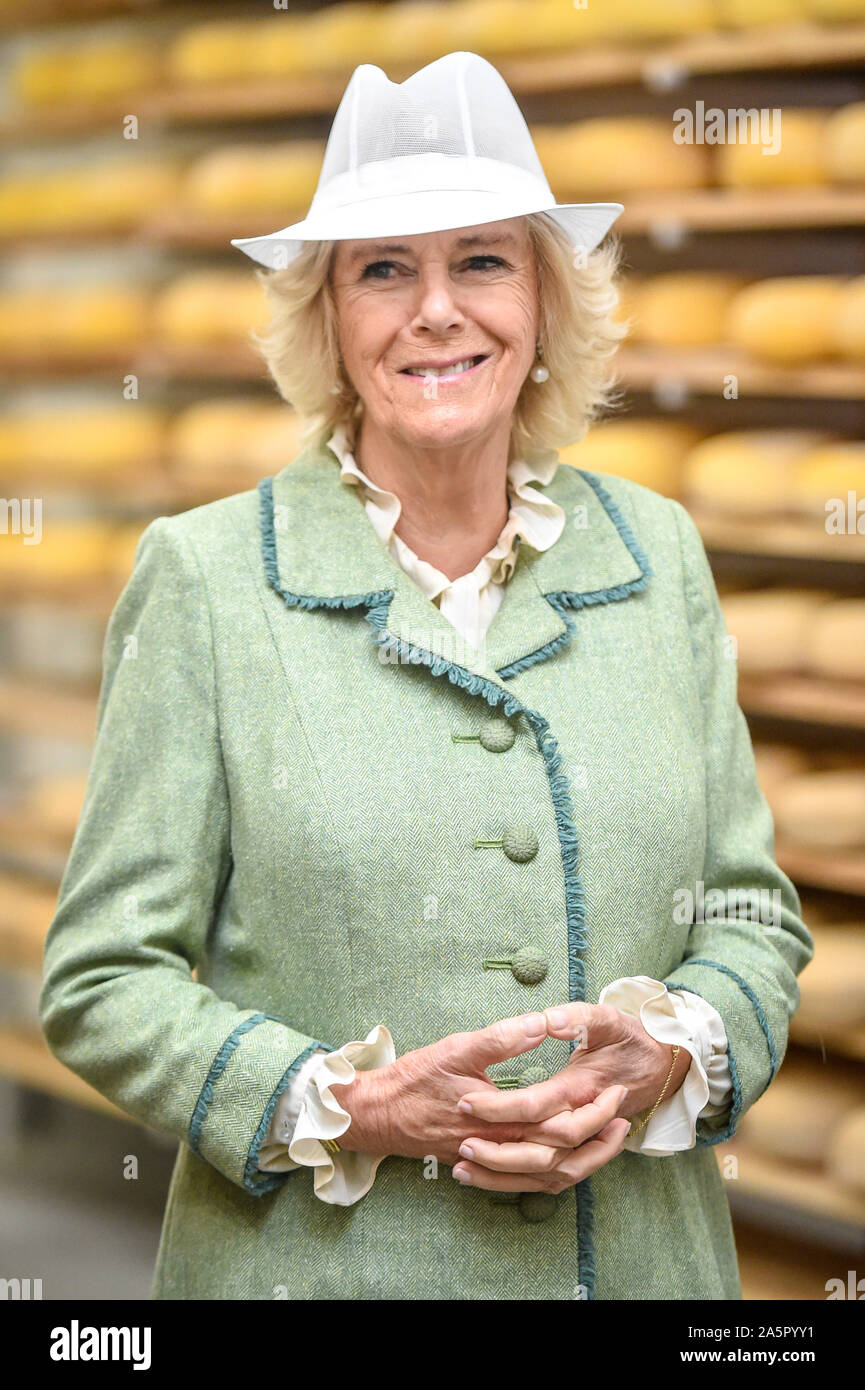 The Duchess of Cornwall wears a white food production hat during a