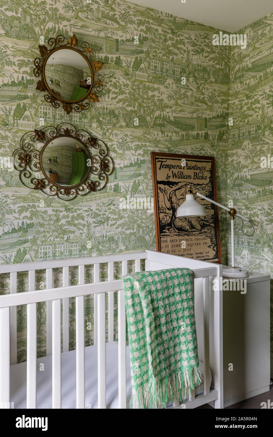 Decorative mirrors above cot with vintage print in child's nursery Stock Photo