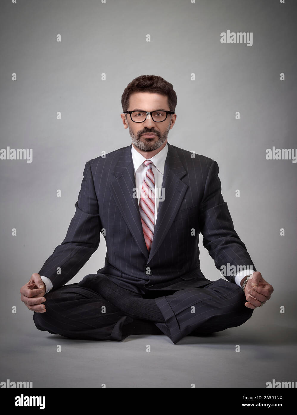 Businessman in half lotus cross legged pose Stock Photo
