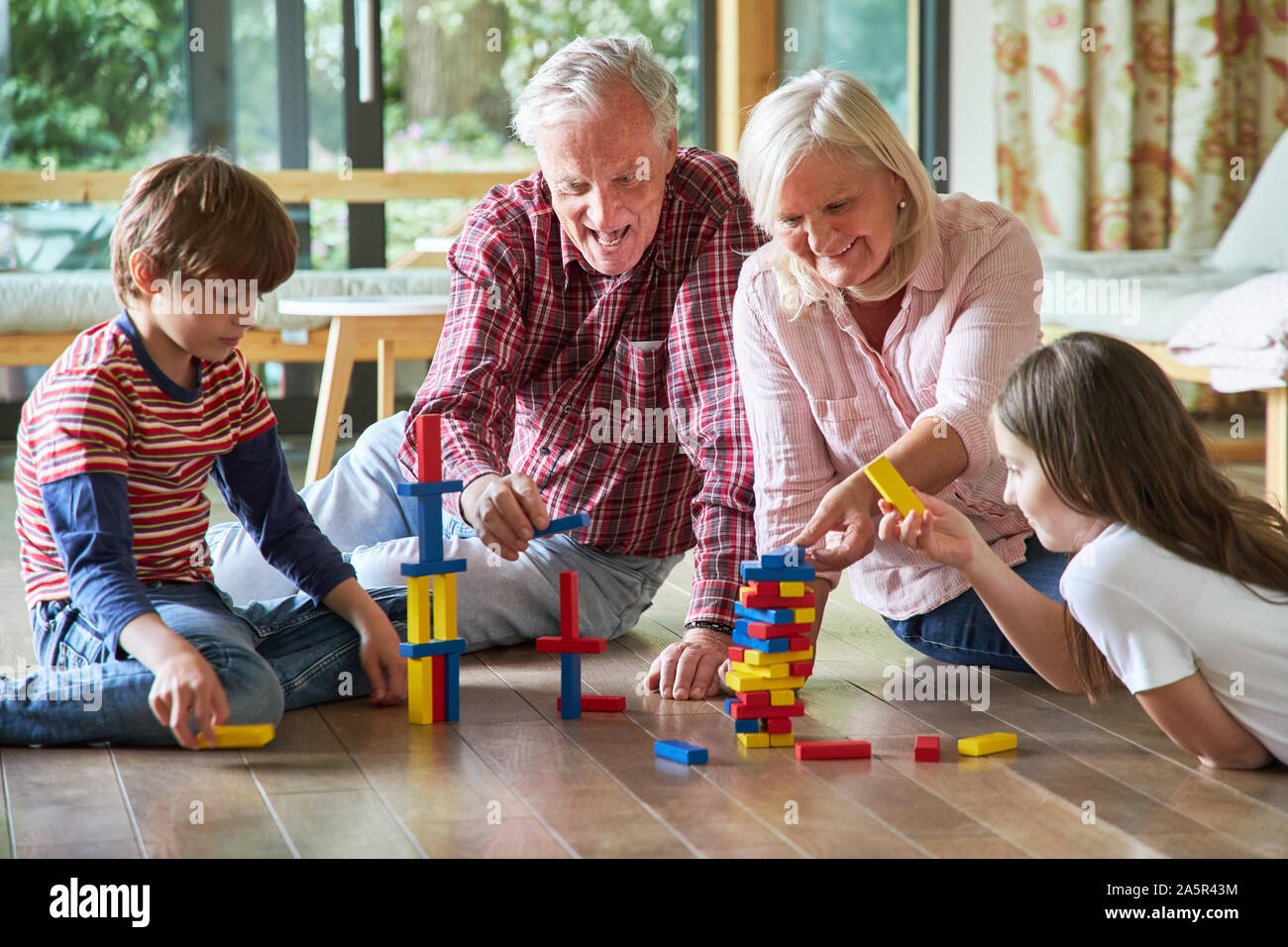Grandparents are stacking building blocks together with their