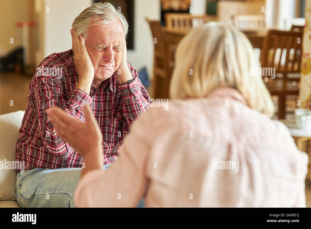 Senior man covers his ears during a rage or quarrel Stock Photo