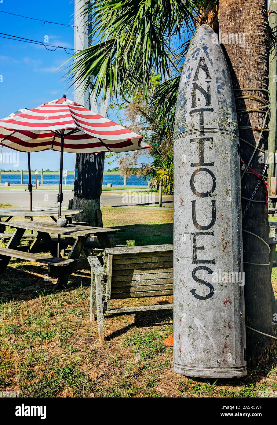 The word, “antiques,” is painted on a vintage torpedo at The Tin Shed, Oct. 6, 2019, in Apalachicola, Florida. The store sells both antique and reprod Stock Photo