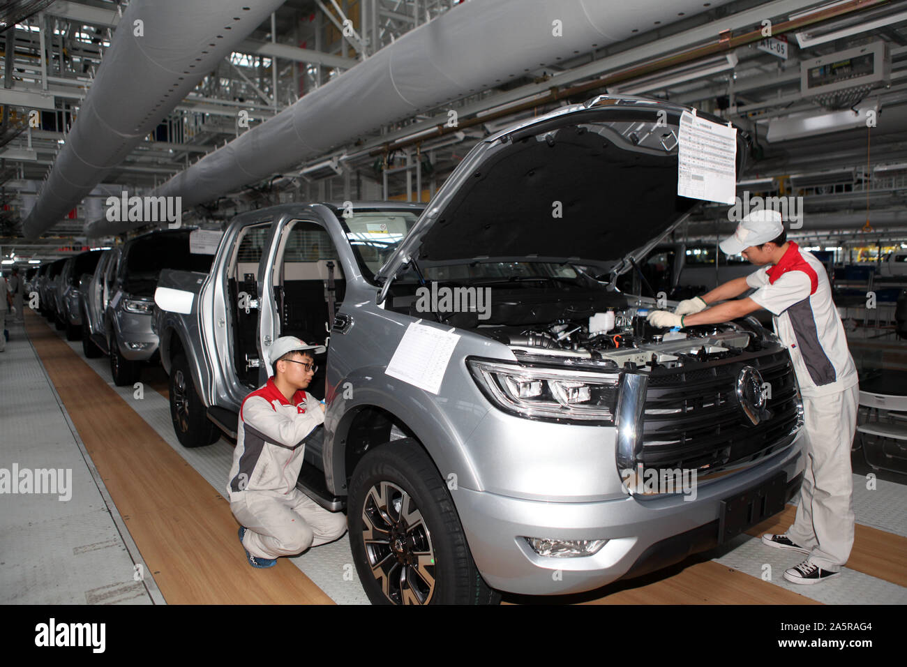 Chinese workers assemble cars on the assembly line at the auto plant of Great Wall Motors in Chongqing, China on October 22nd, 2019. Stock Photo