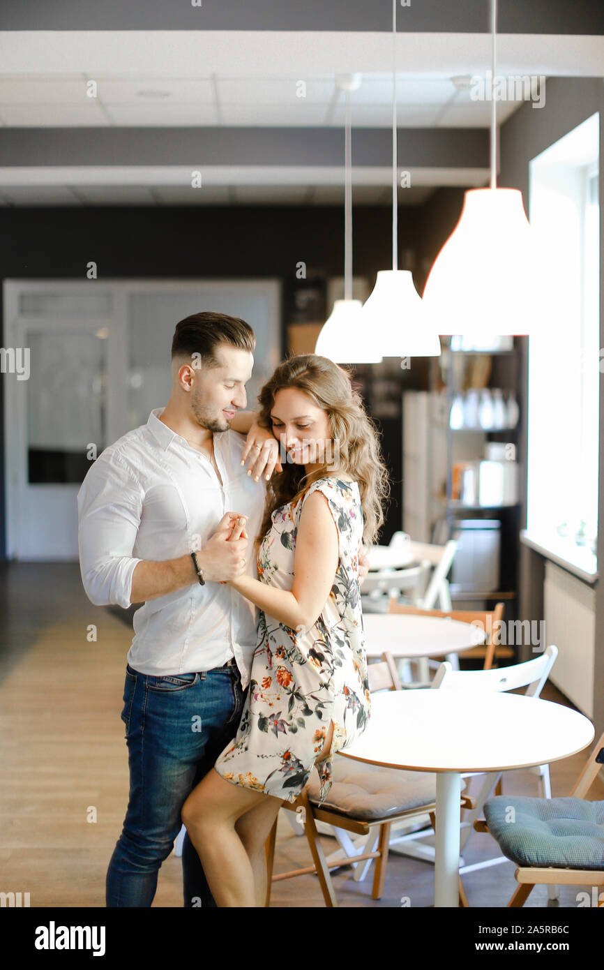 Young handsome man hugging woman and standing at cafe Stock Photo - Alamy