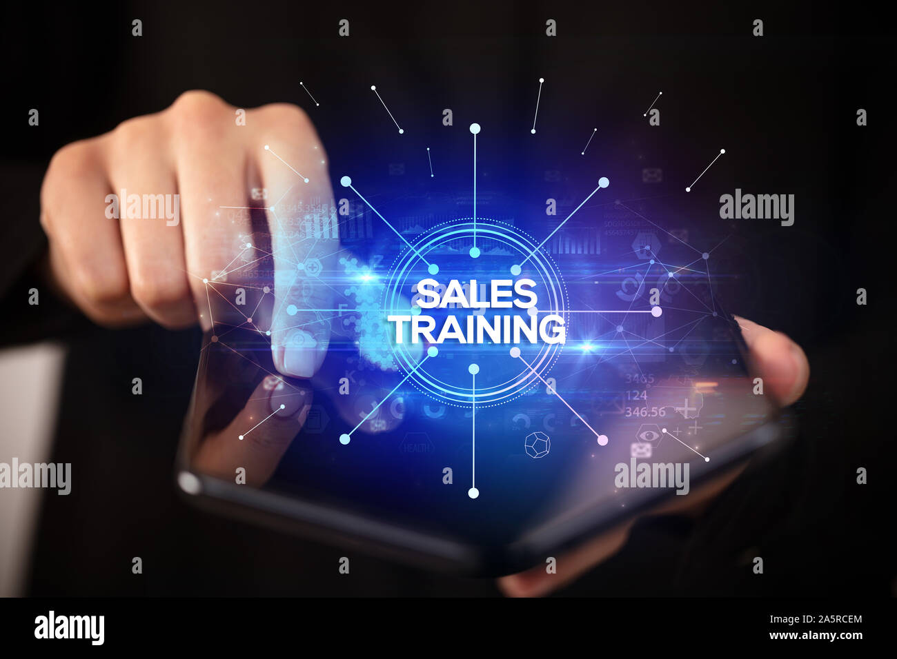 Businessman holding a foldable smartphone with SALES TRAINING inscription, new business concept Stock Photo