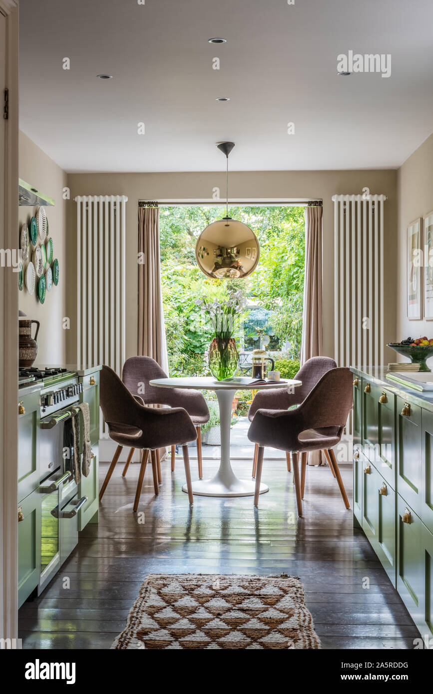 1960s style seating at table in window of Victorian terrace renovation Stock Photo
