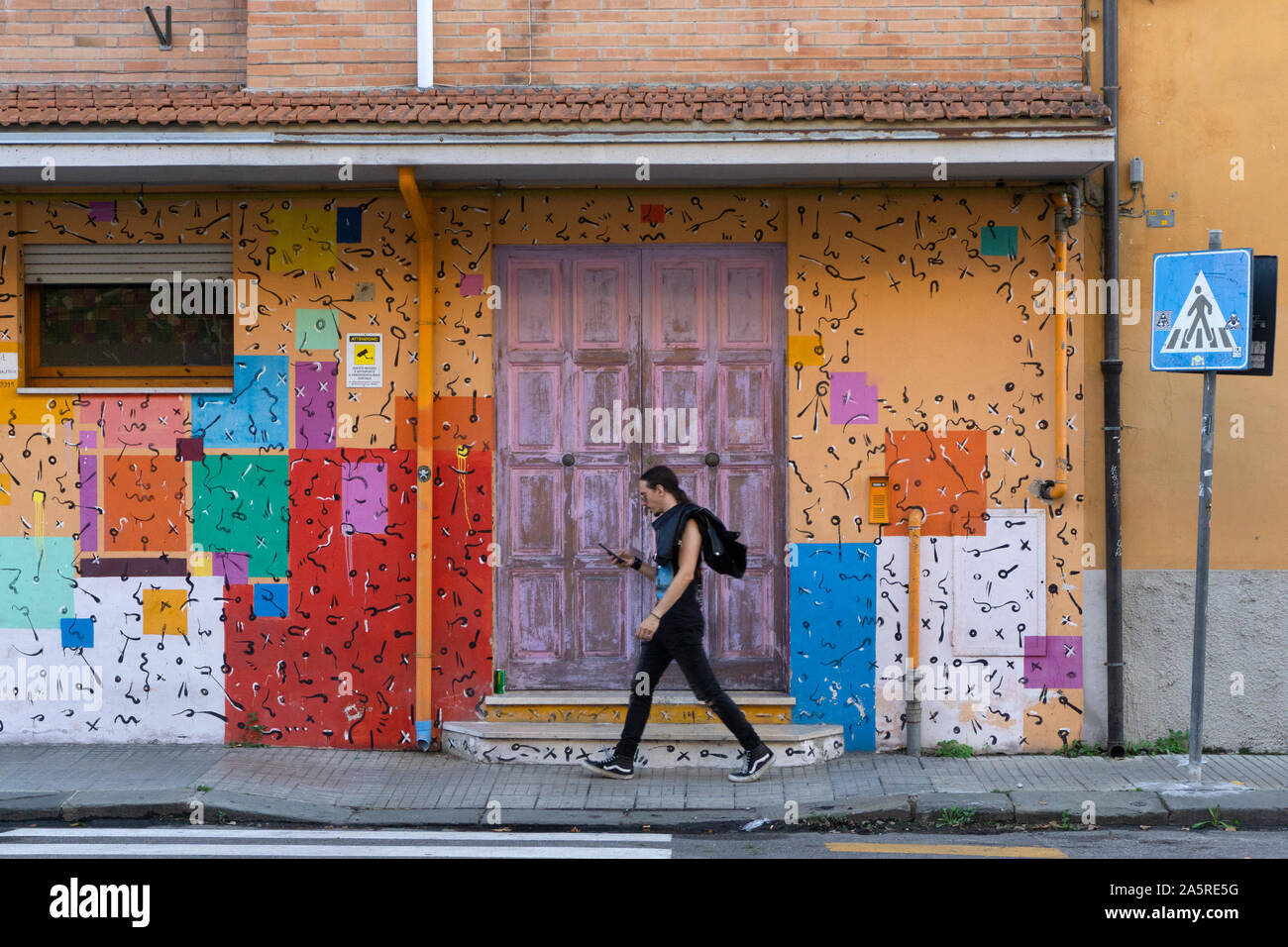 man walking multi colored entrance youth hostel pisa italy Stock Photo