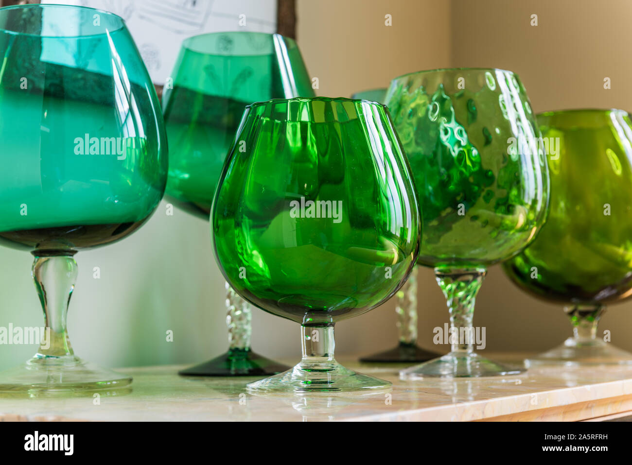 Vintage green glassware on antique sideboard. Stock Photo
