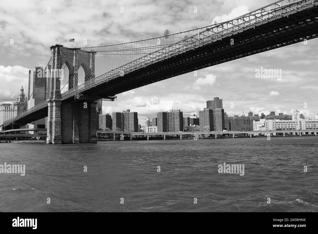 View from the East River in New York City, of the Manhattan end of the famous Brooklyn Bridge, which links the boroughs of Manhattan and Brooklyn. Stock Photo