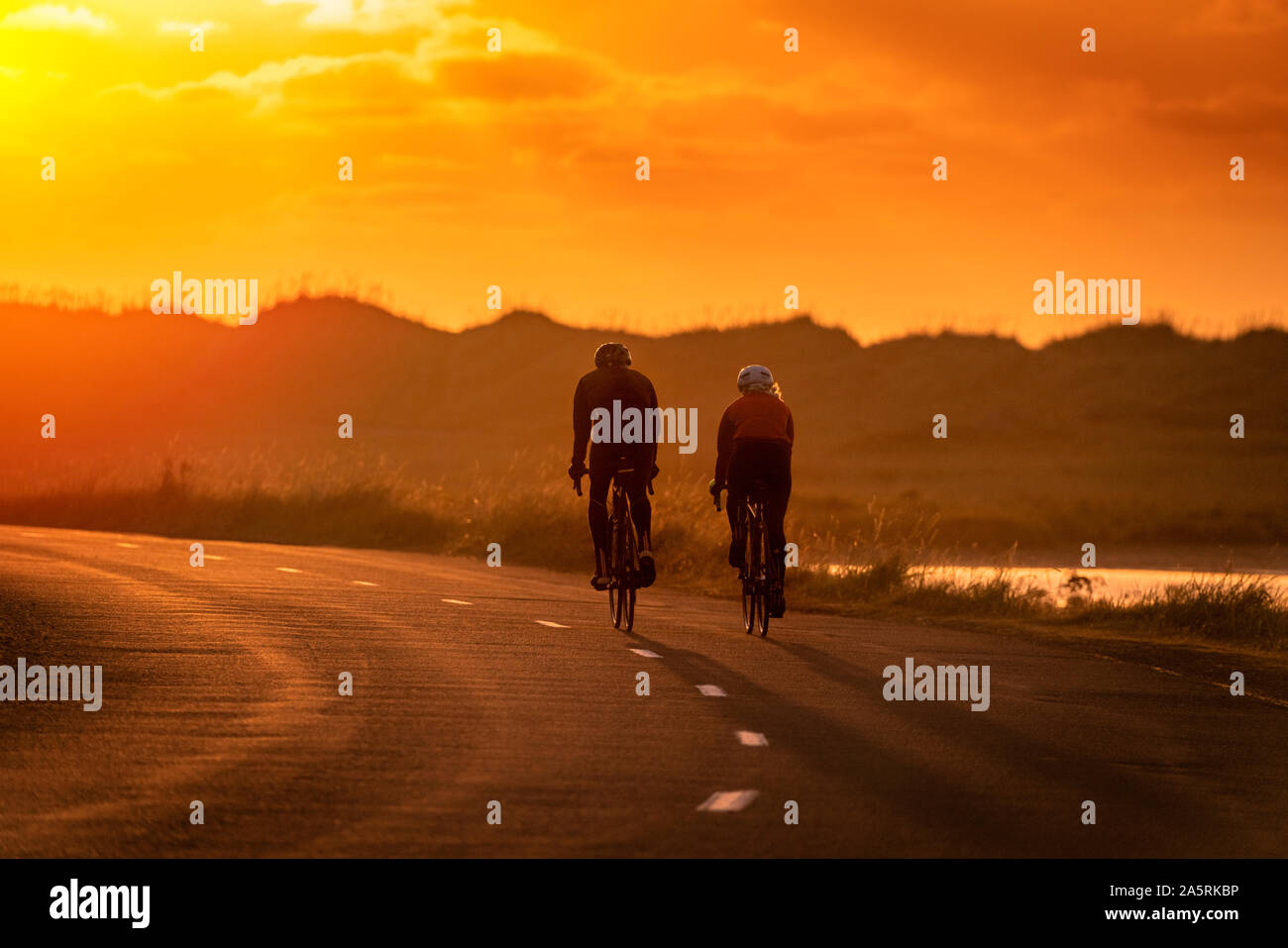 Couple bicycling at sunset, Reykjavik, Iceland Stock Photo