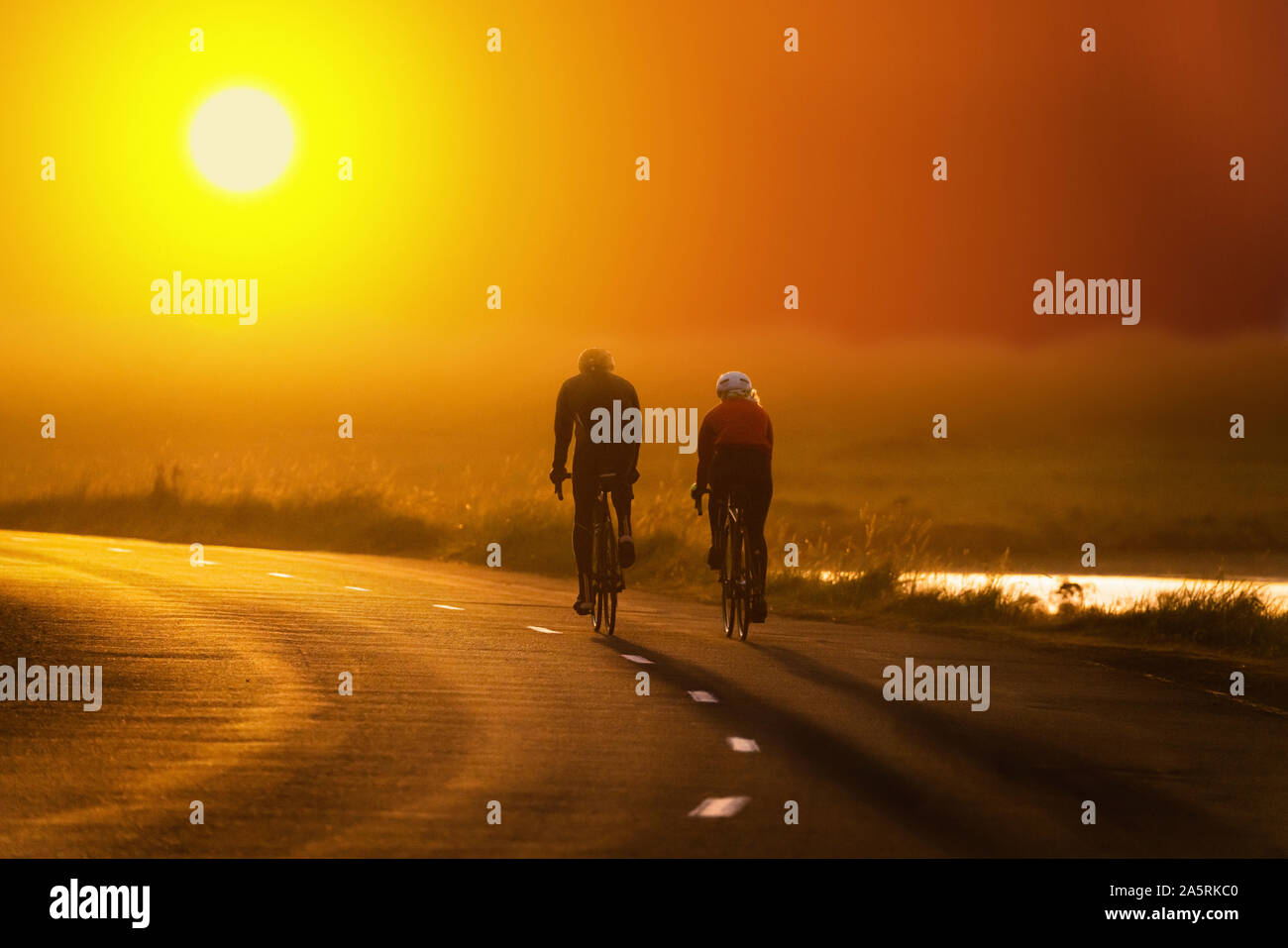Couple bicycling at sunset, Reykjavik, Iceland Stock Photo
