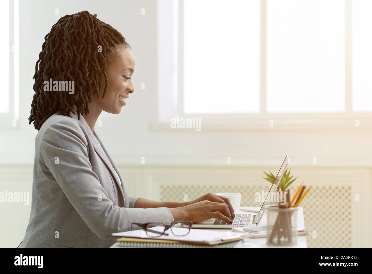 African American Woman Working On Laptop In Office, Side View Stock ...