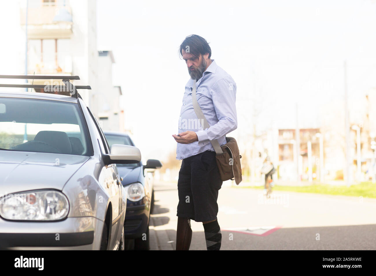 older man with prosthetic leg opening car Stock Photo