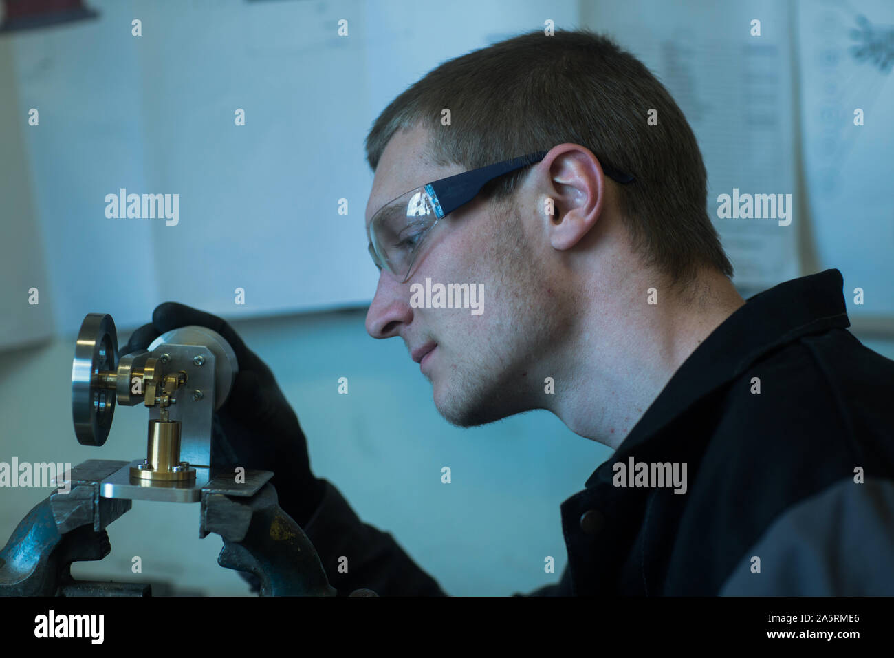 engineer in a workshop looking to a tool Stock Photo