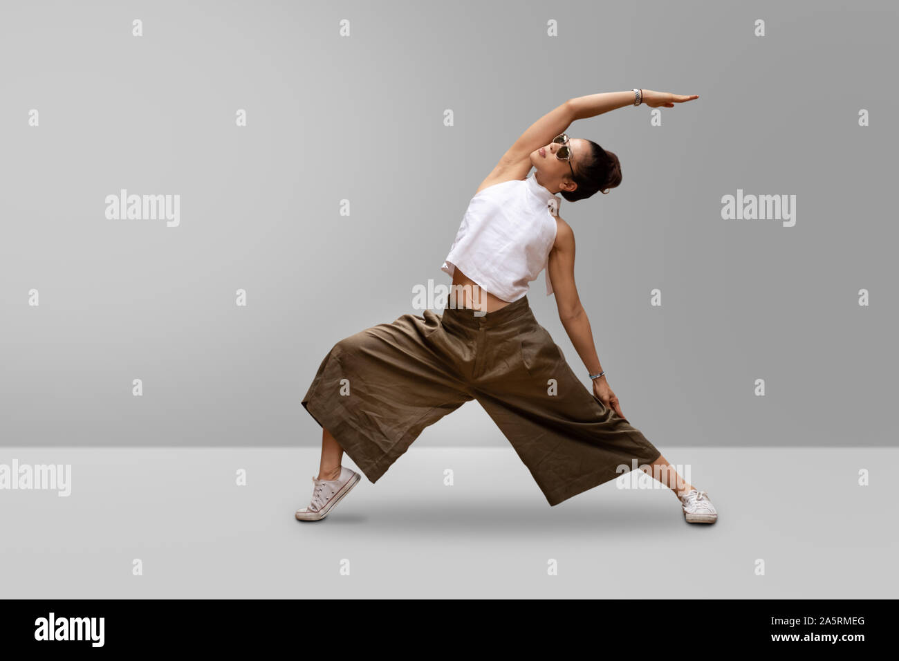 Young woman practicing yoga, standing in Reverse Warrior pose. Stock Photo