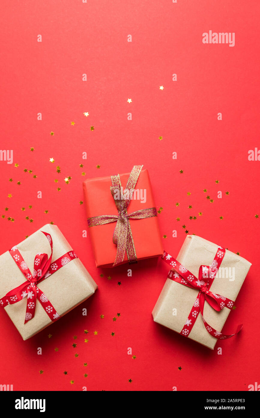 Bright in craft multicolor paper surprise boxes with gold shiny bow ribbons on a red background. Can use for birthday banner, story, birthday poster o Stock Photo