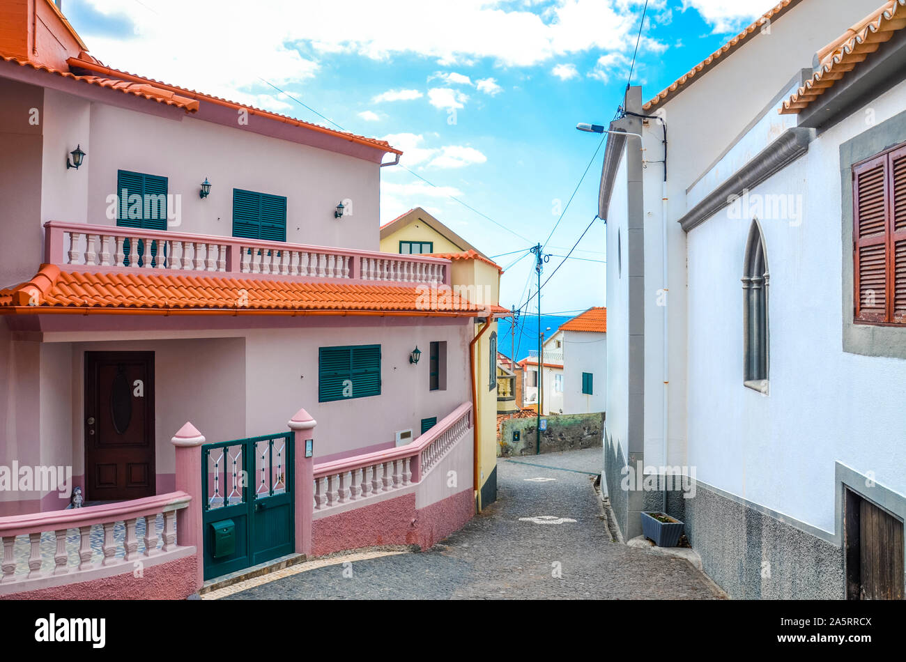 Buildings in coastal village Jardim do Mar, Madeira, Portugal. Waters of the Atlantic ocean in the background. Narrow street. Tourist destination. Pink facade. Stock Photo