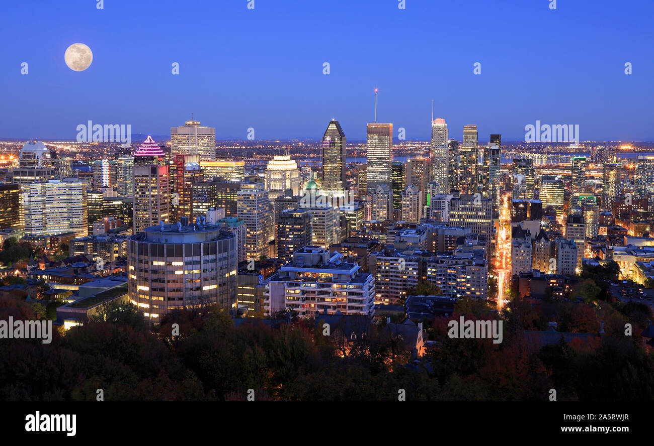 Colorful Montreal skyline at night including a beautiful full moon on the sky, Canada Stock Photo