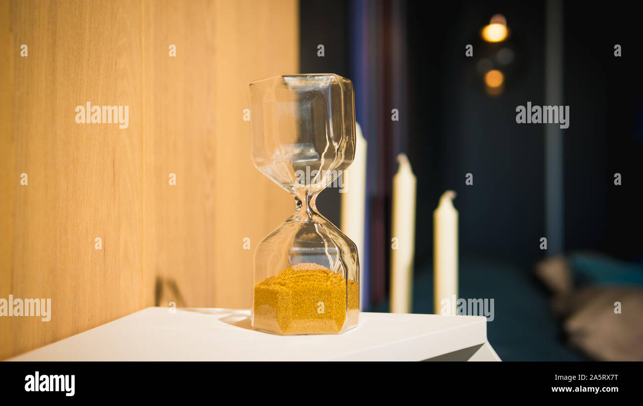 Sand running through the bulbs of an hourglass. Hourglass as time passing concept for business deadline Stock Photo