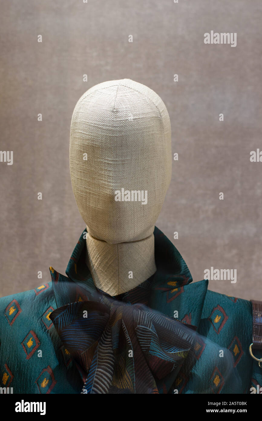 Fabric mannequin, bald linen head with a large dark bow. Rag mannequin