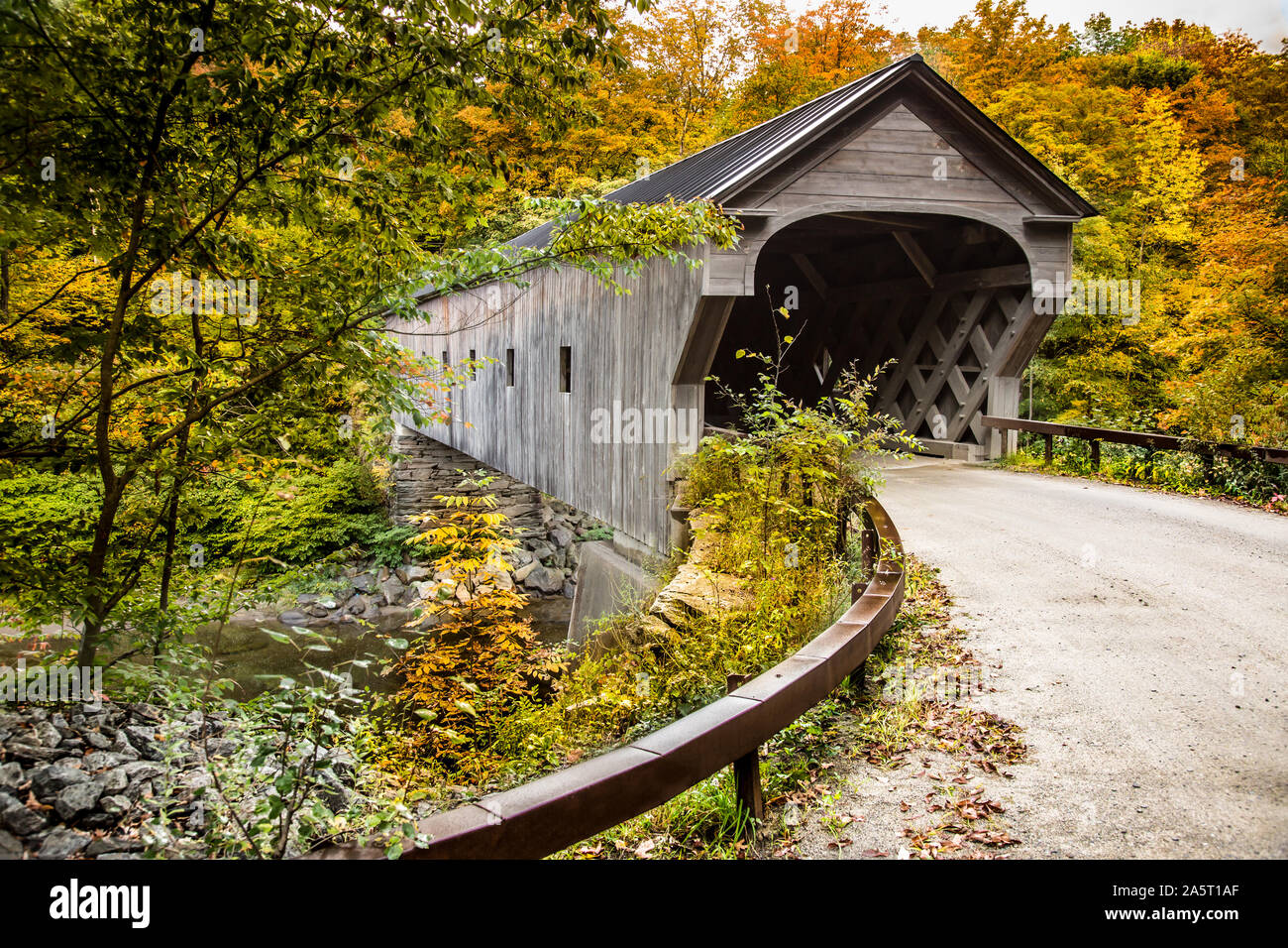 Upper Falls Covered Bridge in Weathersfield, Vermont. Autumn leaves and Black  River running underneath this covered bridge. Stock Photo